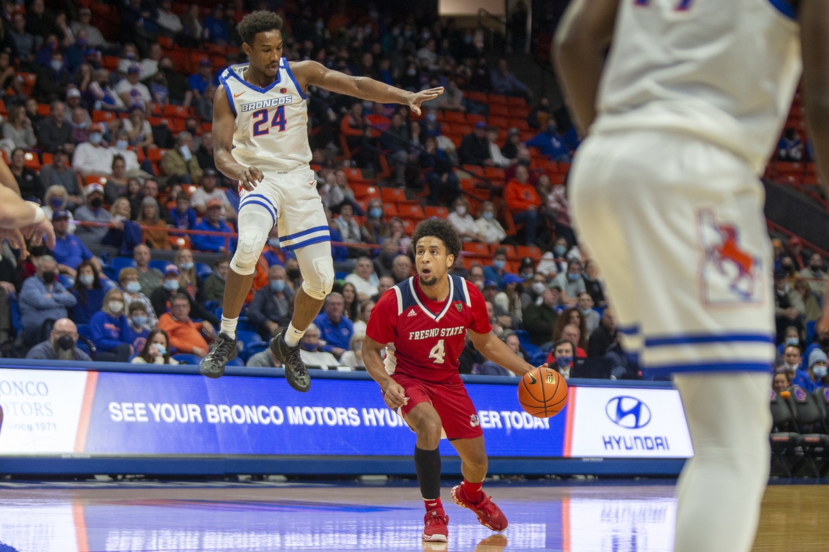 Dec 28, 2021; Boise, Idaho, USA; Fresno State Bulldogs guard Junior Ballard (4) dribbles the ball against Boise State Broncos forward Abu Kigab (24) during the first half at ExtraMile Arena. Mandatory Credit: Brian Losness-USA TODAY Sports