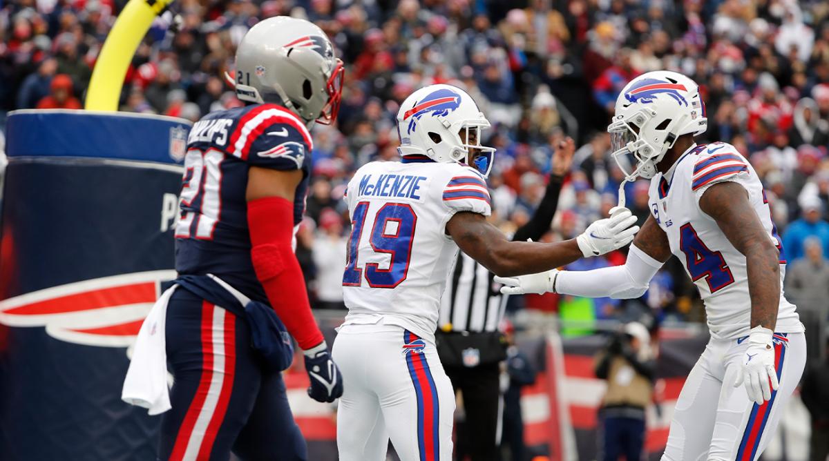 Buffalo Bills wide receiver Isaiah McKenzie (19) is congratulated by Stefon Diggs (14) after his touchdown during the first half of an NFL football game, Sunday, Dec. 26, 2021, in Foxborough, Mass. At left is New England Patriots safety Adrian Phillips (21).