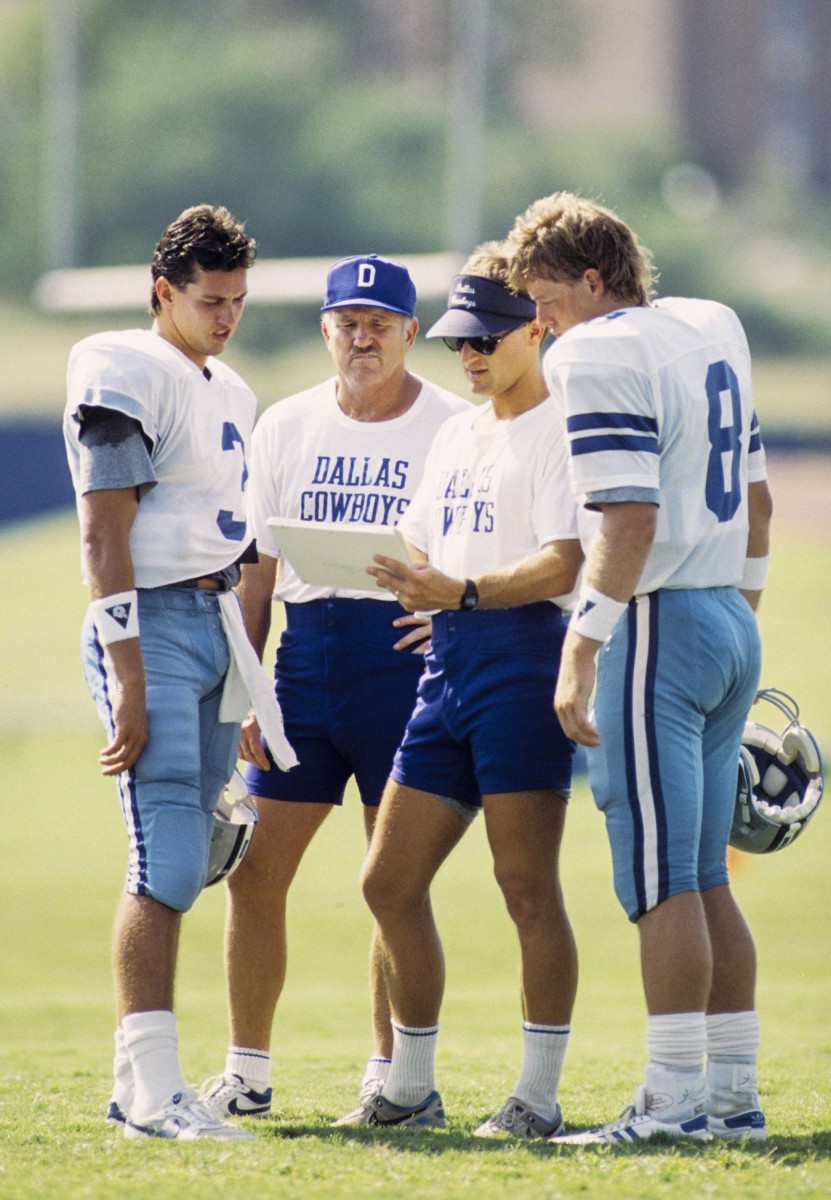 Dallas Cowboys offensive coordinator David Shula and offense line coach Jim Erkenbeck talk with quarterbacks Steve Walsh (3) and Troy Aikman (8) during training camp prior to the 1989 season.