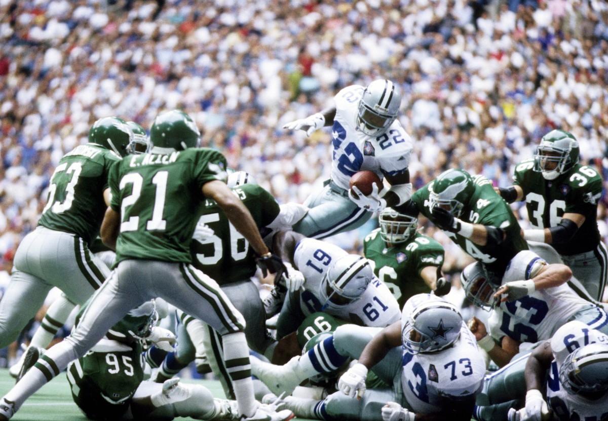 Dallas Cowboys running back Emmitt Smith (22) dives into the end zone for a touchdown behind the blocking of Nate Newton (61) and Larry Allen (73) against the Philadelphia Eagles at Texas Stadium.