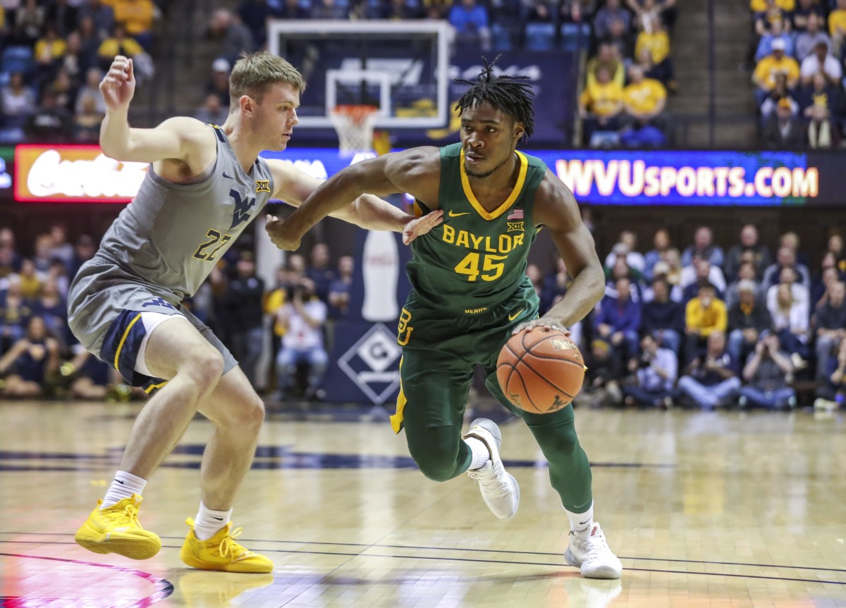 Mar 7, 2020; Morgantown, West Virginia, USA; Baylor Bears guard Davion Mitchell (45) dribbles past West Virginia Mountaineers guard Sean McNeil (22) during the first half at WVU Coliseum.