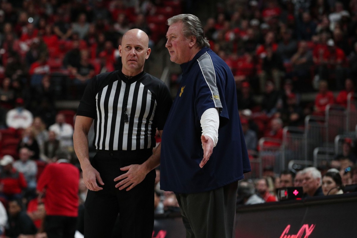 Jan 22, 2022; Lubbock, Texas, USA; West Virginia Mountaineers head coach Bob Huggins discusses a call in the first half with Big 12 official Kipp Kissinger during the game against the Texas Tech Red Raiders at United Supermarkets Arena.