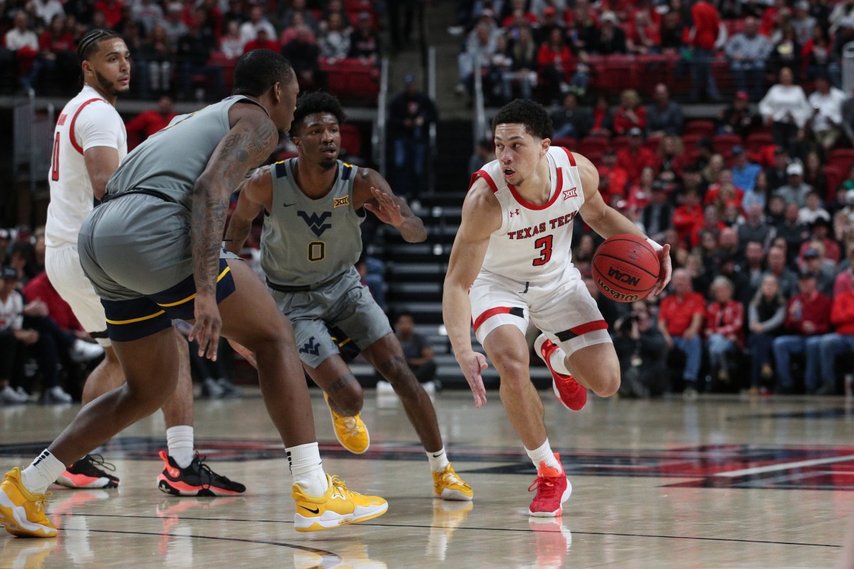 Jan 22, 2022; Lubbock, Texas, USA; Texas Tech Red Raiders guard Clarence Nadolny (3) dribbles the ball against West Virginia Mountaineers guard Kedrian Johnson (0) and forward Gabe Osabuohien (3) in the first half at United Supermarkets Arena.