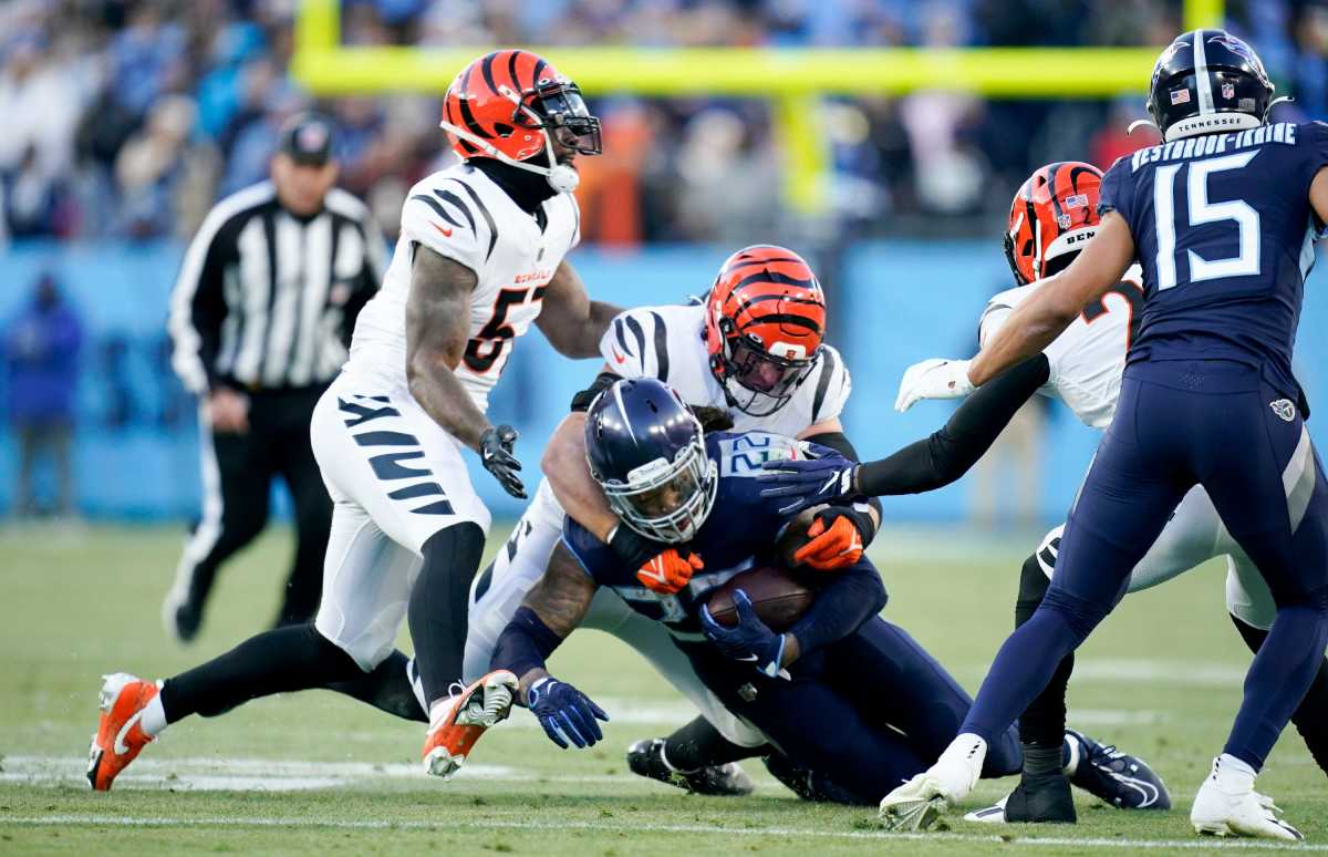 Tennessee Titans running back Derrick Henry (22) is brought down by Cincinnati Bengals linebackers Logan Wilson (55) and Germaine Pratt (57) during the second quarter of an AFC divisional playoff game at Nissan Stadium Saturday, Jan. 22, 2022 in Nashville, Tenn. Titans Bengals 145