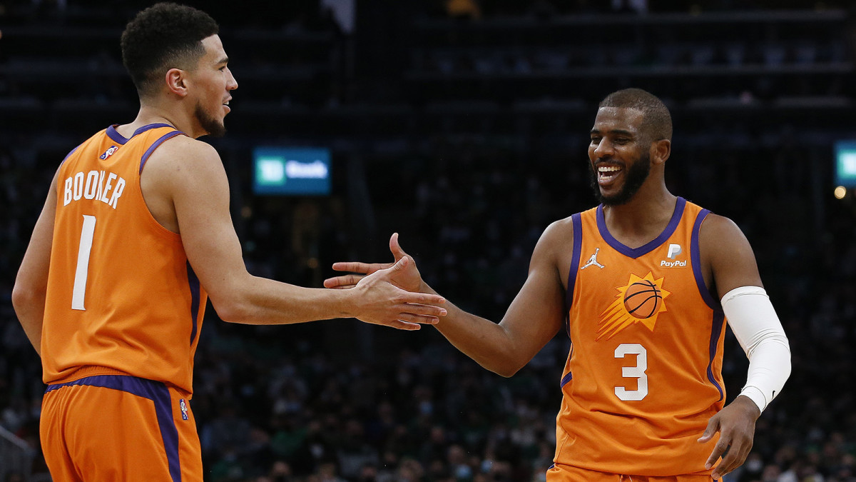 Phoenix Suns guards Devin Booker Chris Paul celebrate after a basket against the Boston Celtics.