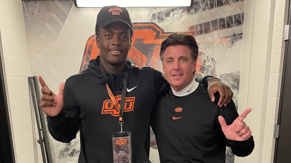 Trey Wilson and Oklahoma State coach pose for a photo.