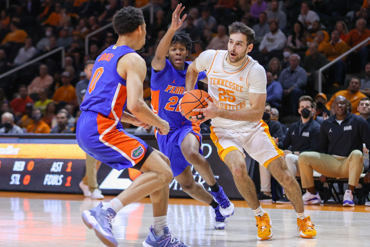 Tennessee Volunteers guard Santiago Vescovi (25) moves the ball against Florida Gators guard Myreon Jones (0) and guard Brandon McKissic (23) during the first half at Thompson-Boling Arena.