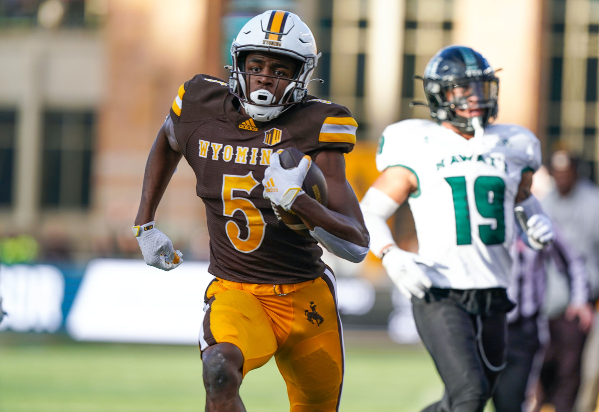 Nov 27, 2021; Laramie, Wyoming, USA; Wyoming Cowboys wide receiver Isaiah Neyor (5) scores a touchdown against the Hawaii Rainbow Warriors during the fourth quarter at Jonah Field at War Memorial Stadium.