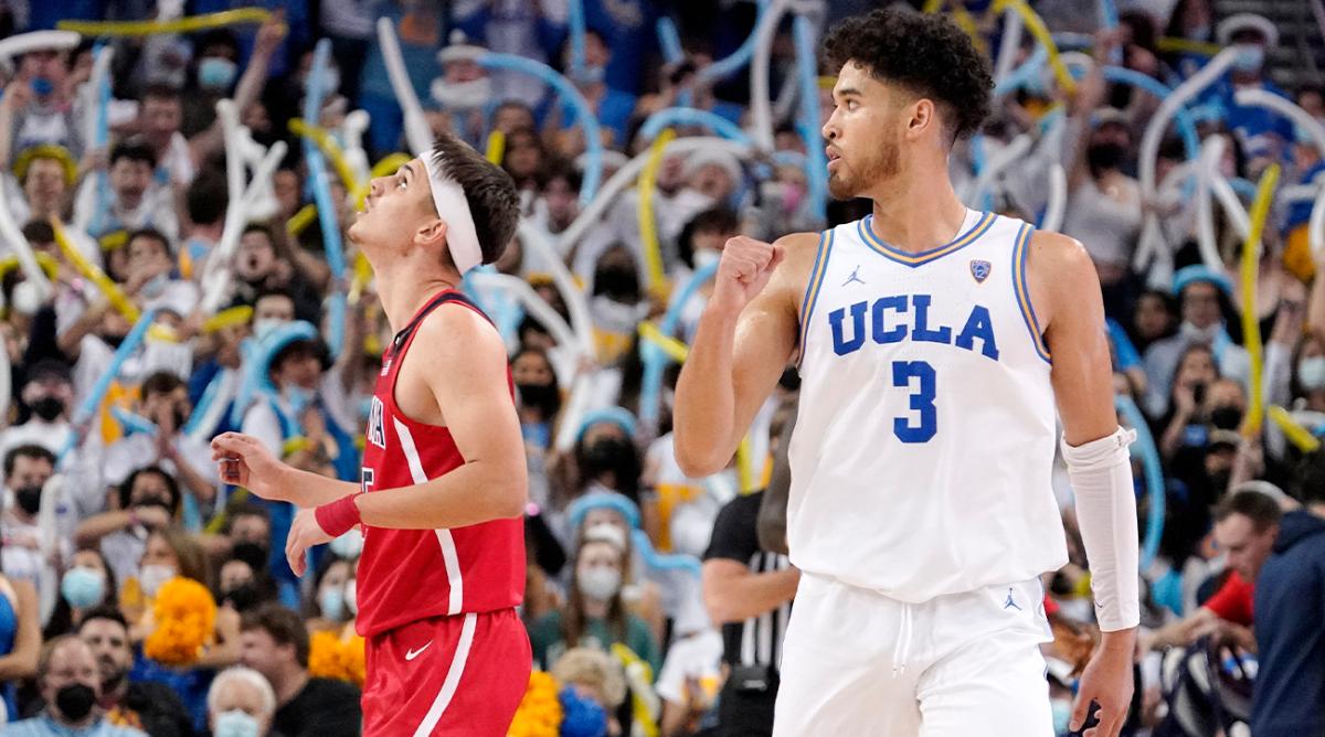 UCLA guard Johnny Juzang, right, celebrates a turnover as Arizona guard Kerr Kriisa looks toward the scoreboard during the second half of an NCAA college basketball game Tuesday, Jan. 25, 2022, in Los Angeles.