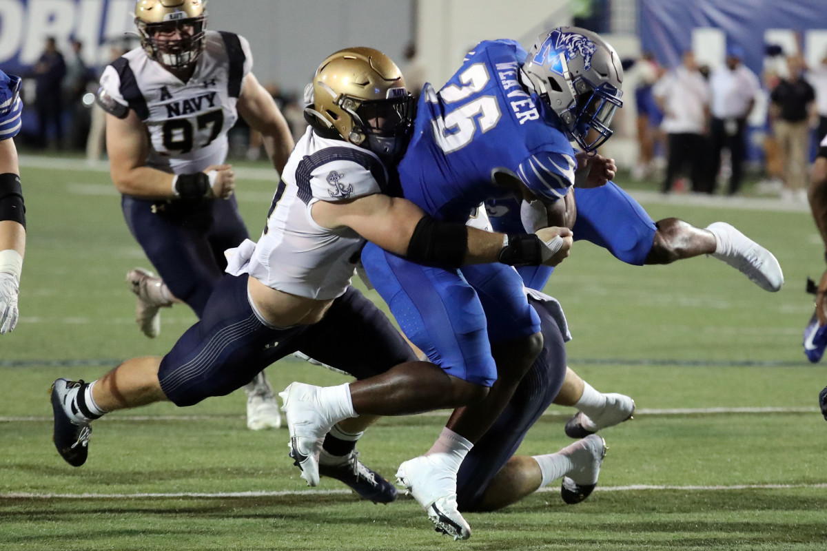 Oct 14, 2021; Memphis, Tennessee, USA; Memphis Tigers running back Marquavius Weaver (26) runs the ball for a first down as Navy Midshipmen linebacker Johnny Hodges (57) makes the tackle during the second half at Liberty Bowl
