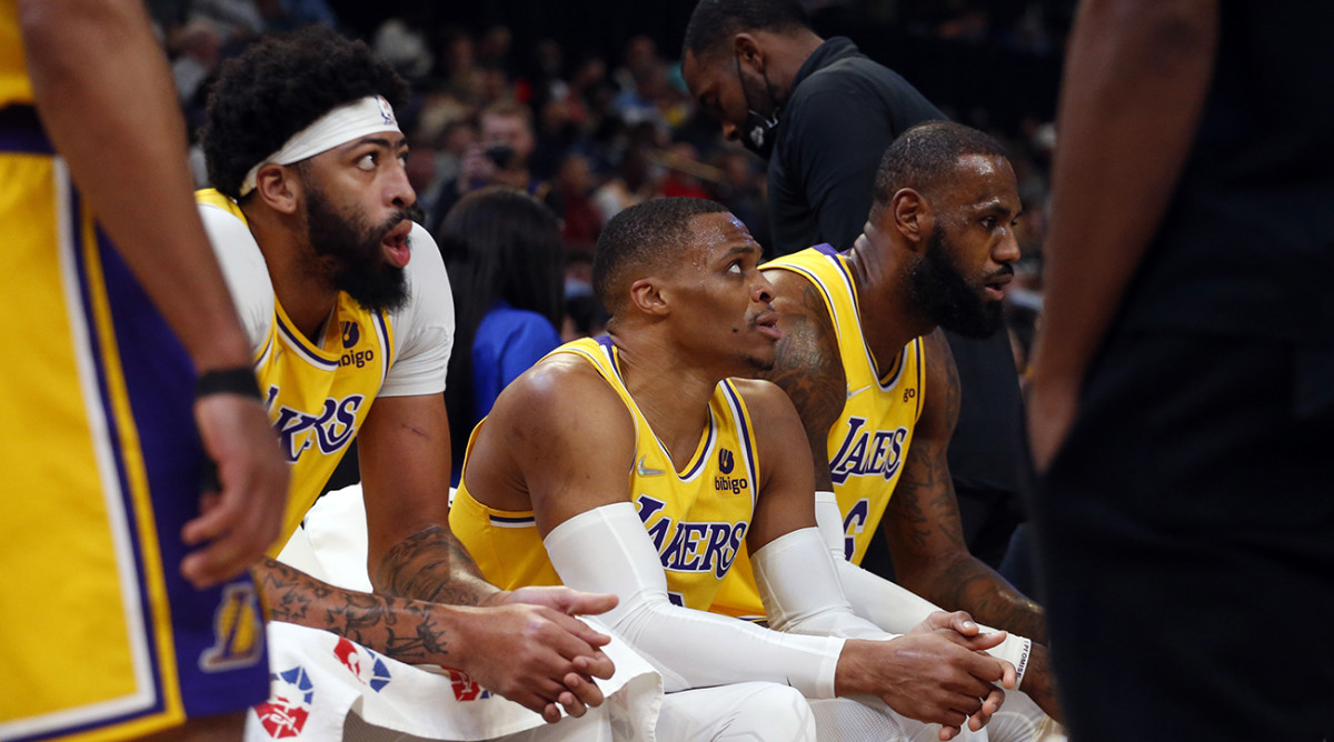 Anthony Davis (left), Russell Westbrook (center) and LeBron James (right) sit on the bench.