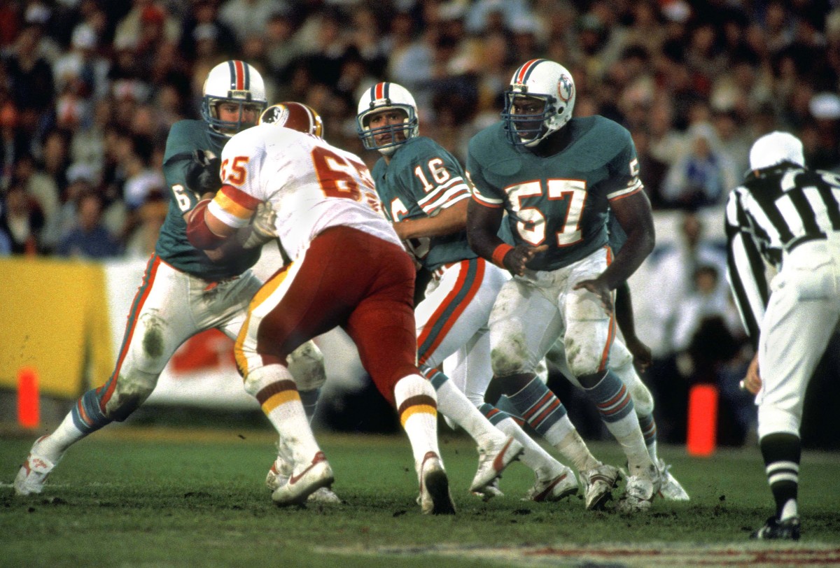 Miami Dolphins quarterback (16) David Woodley drops back to pass behind center (57) Dwight Stephenson against the Washington Redskins during Super Bowl XVII at the Rose Bowl.