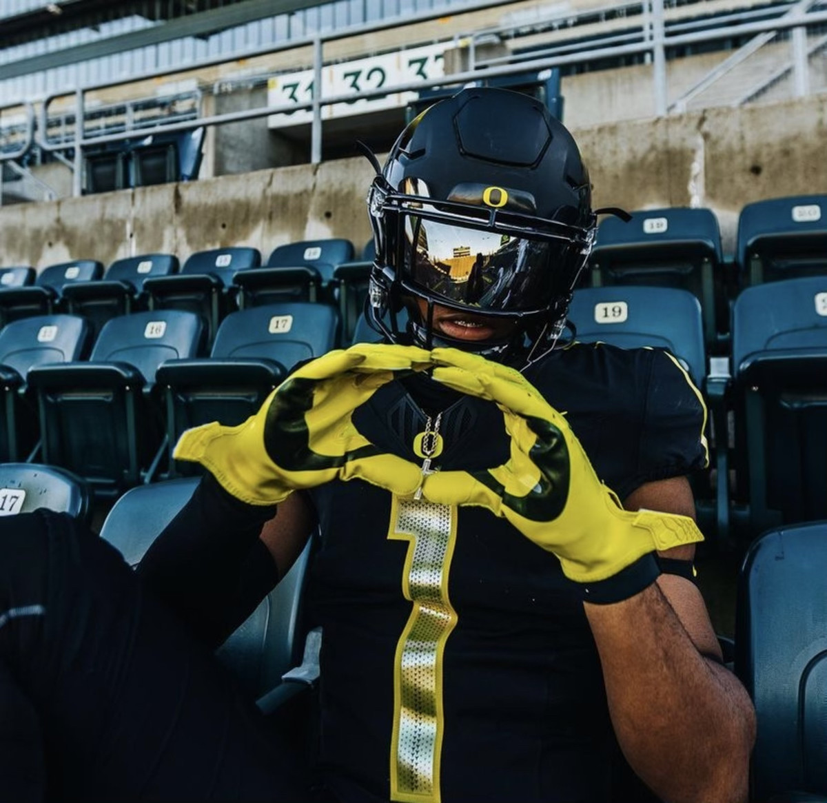 Williams throws up an O in the stands of Autzen Stadium during an official visit to Oregon.