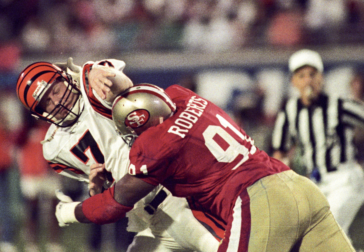 San Francisco 49ers defensive end Larry Roberts (91) tackles Cincinnati Bengals quarterback Boomer Esiason (7) during Super Bowl XXIII at Joe Robbie Stadium.