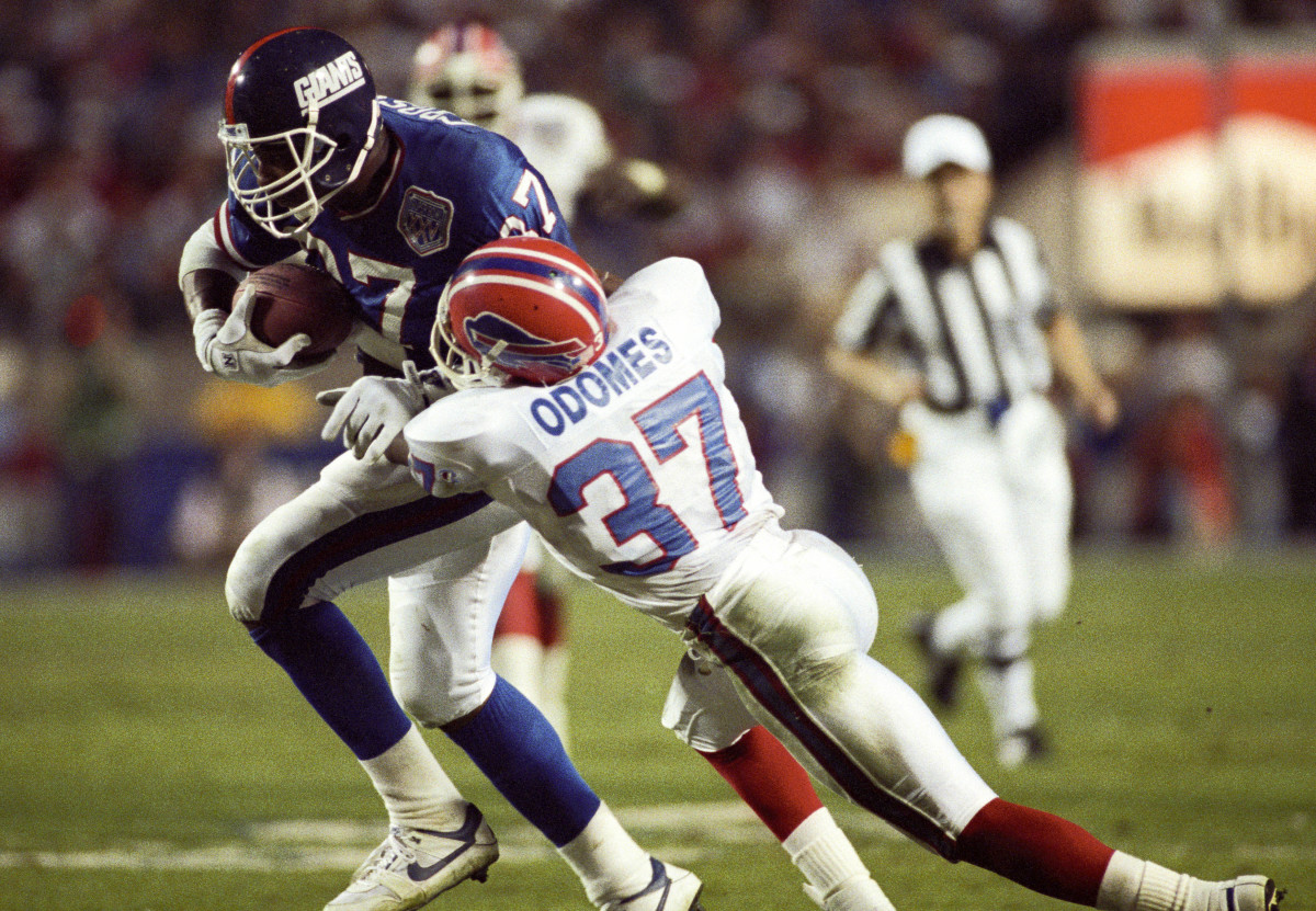 Buffalo Bills cornerback Nate Odomes (37) attempts to tackle New York Giants tight end Howard Cross (87) during Super Bowl XXV at Tampa Stadium.