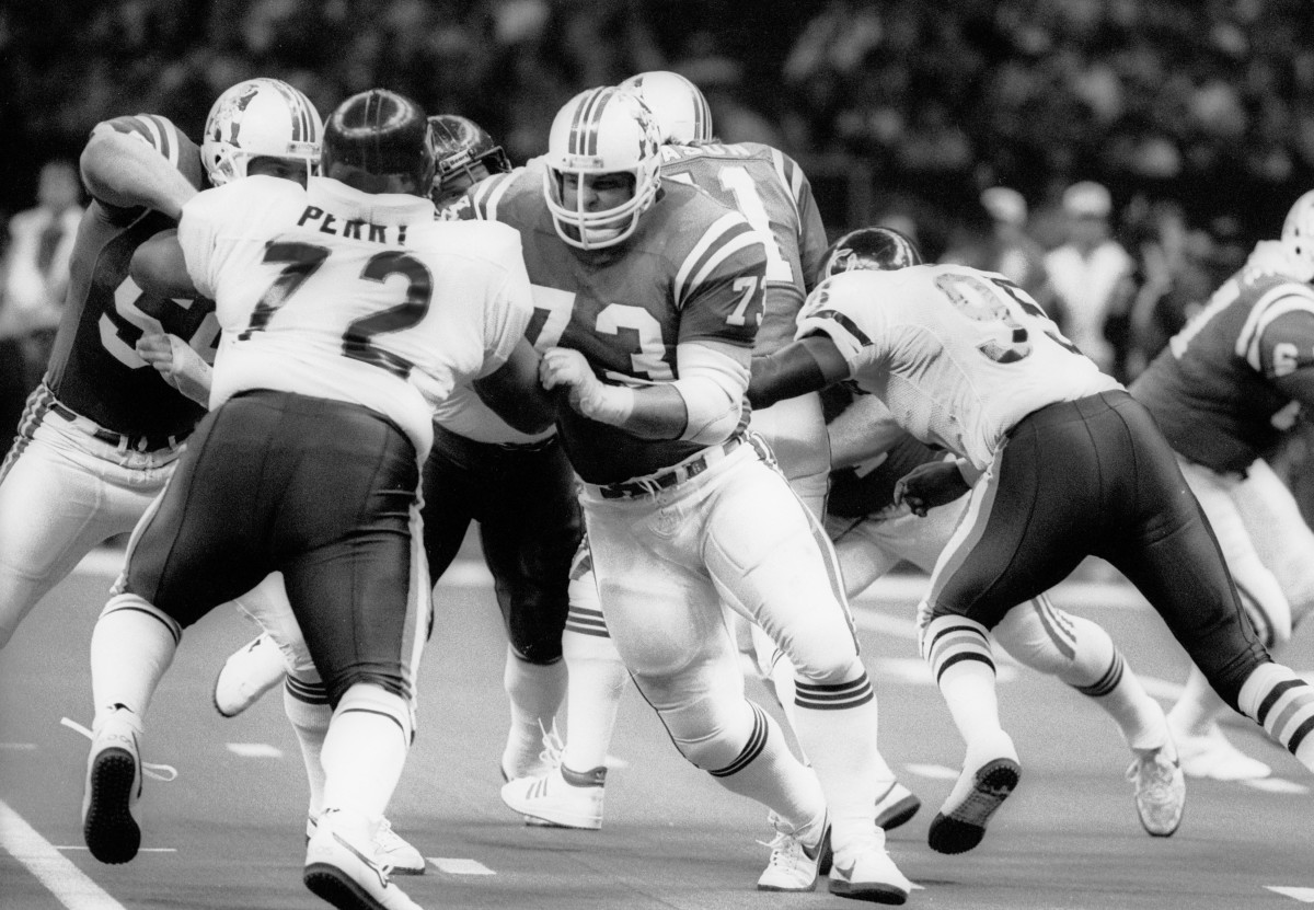 England Patriots tackle John Hannah (73) and Pete Brock (58) block Chicago Bears defensive tackle William Perry (72) during Super Bowl XX at the Superdome.
