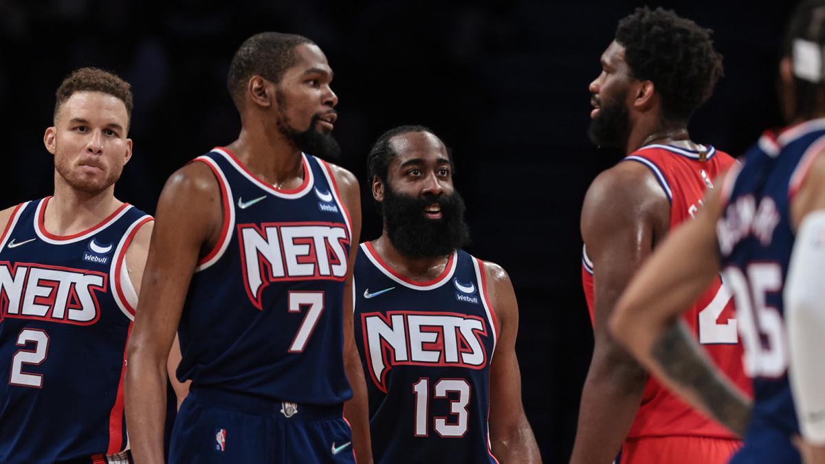 Brooklyn Nets forward Kevin Durant (7) and guard James Harden (13) talk with Philadelphia 76ers center Joel Embiid.