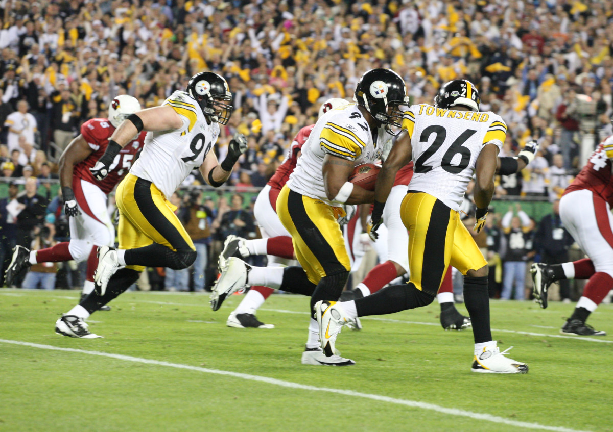 Pittsburgh Steelers linebacker James Harrison (92) carries the ball after an interception en route to a 100-yard touchdown return as cornerback Deshea Townsend (26) blocks in the second quarter of Super Bowl XLIII against the Arizona Cardinals at Raymond James Stadium.