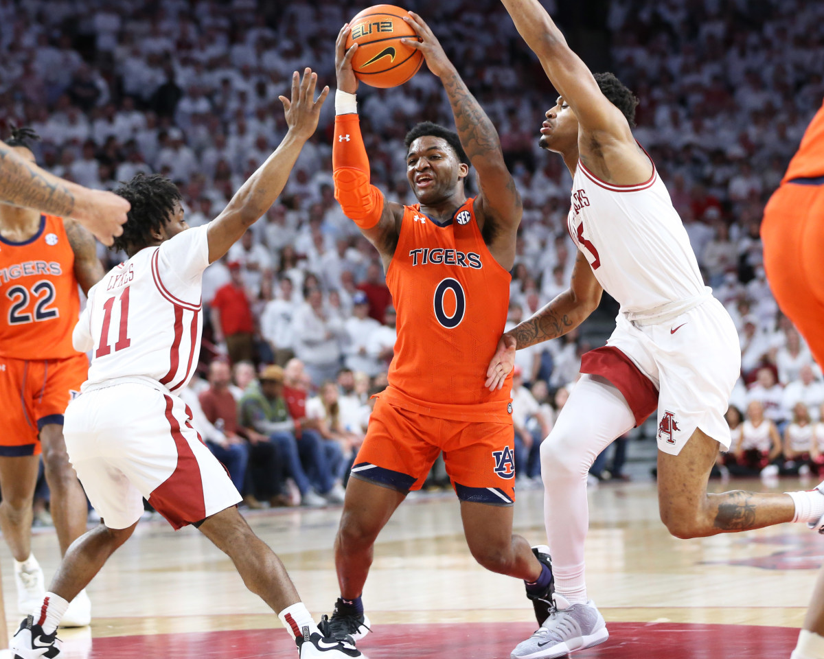 Feb 8, 2022; Fayetteville, Arkansas, USA; Auburn Tigers guard K.D. Johnson (0) drives to the basket in the first half as Arkansas Razorbacks guards Chris Lykes (11) Au'Diese Toney (5) defend at Bud Walton Arena. Mandatory Credit: Nelson Chenault-USA TODAY Sports