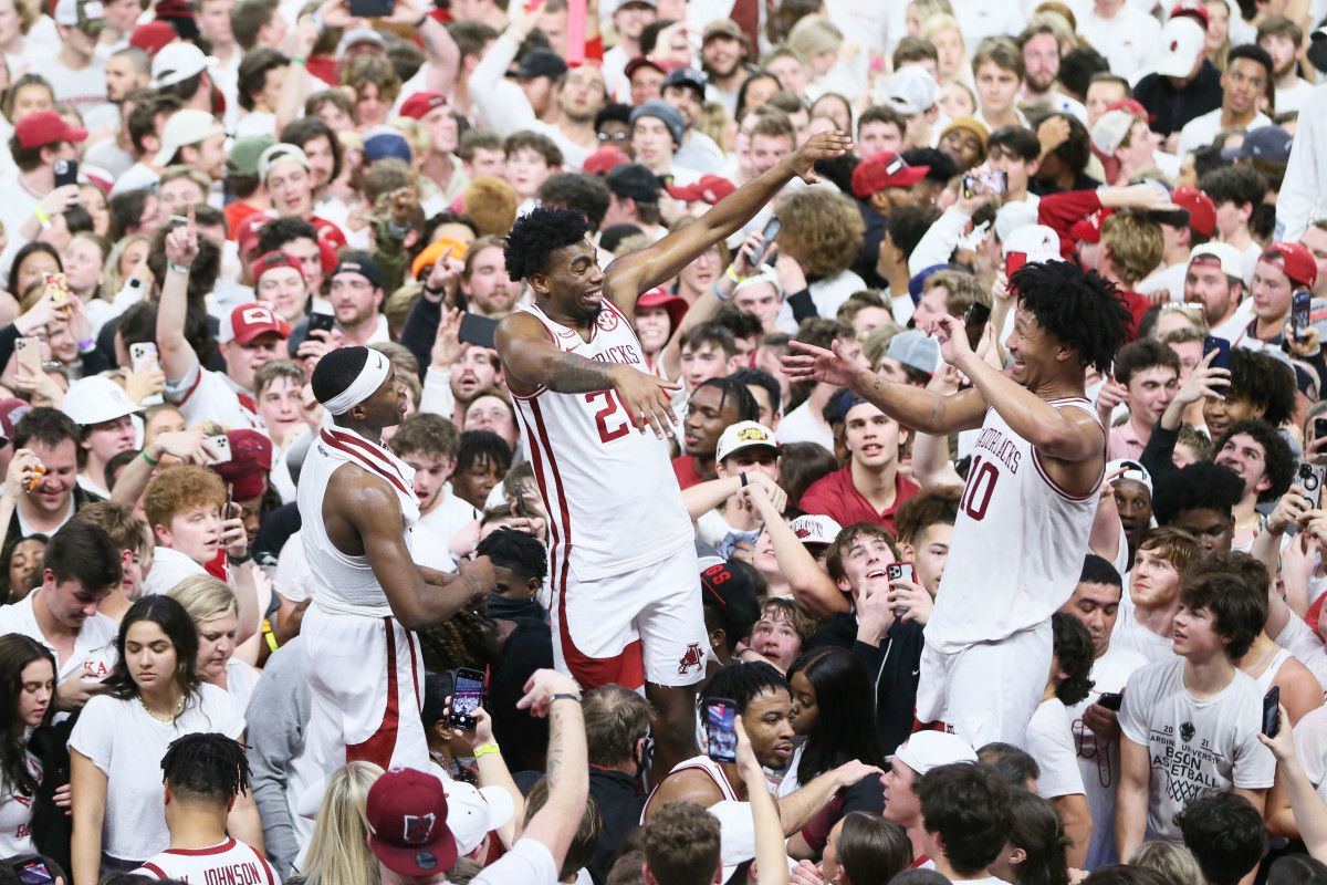 Razorbacks guard Davonte Davis (4) celebrates with forwards Kamani Johnson (20) and Jaylin Williams (10) after the game against the Auburn Tigers at Bud Walton Arena.