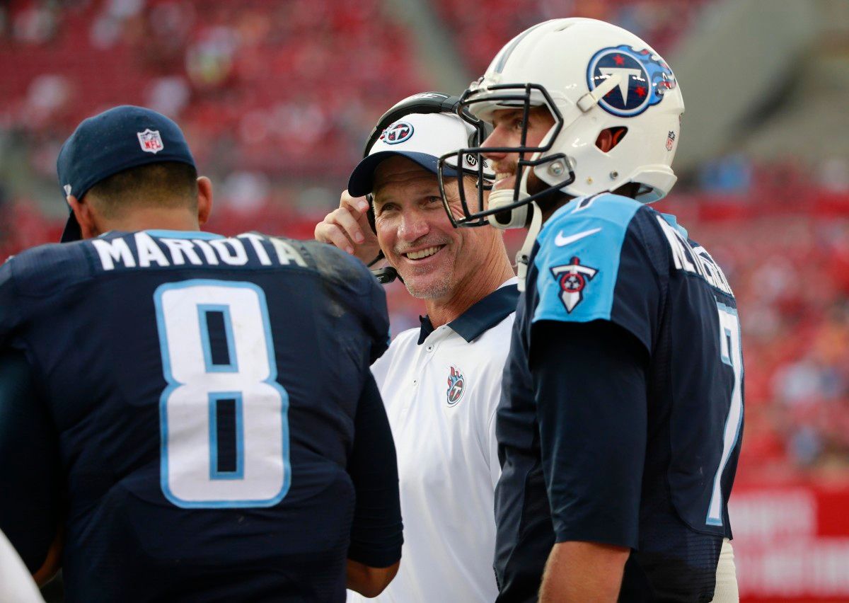 Tennessee Titans head coach Ken Whisenhunt smiles as he talks with quarterback Marcus Mariota (8) and quarterback Zach Mettenberger (7) during the second half against the Tampa Bay Buccaneers at Raymond James Stadium. Tennessee Titans defeated the Tampa Bay Buccaneers 42-14.