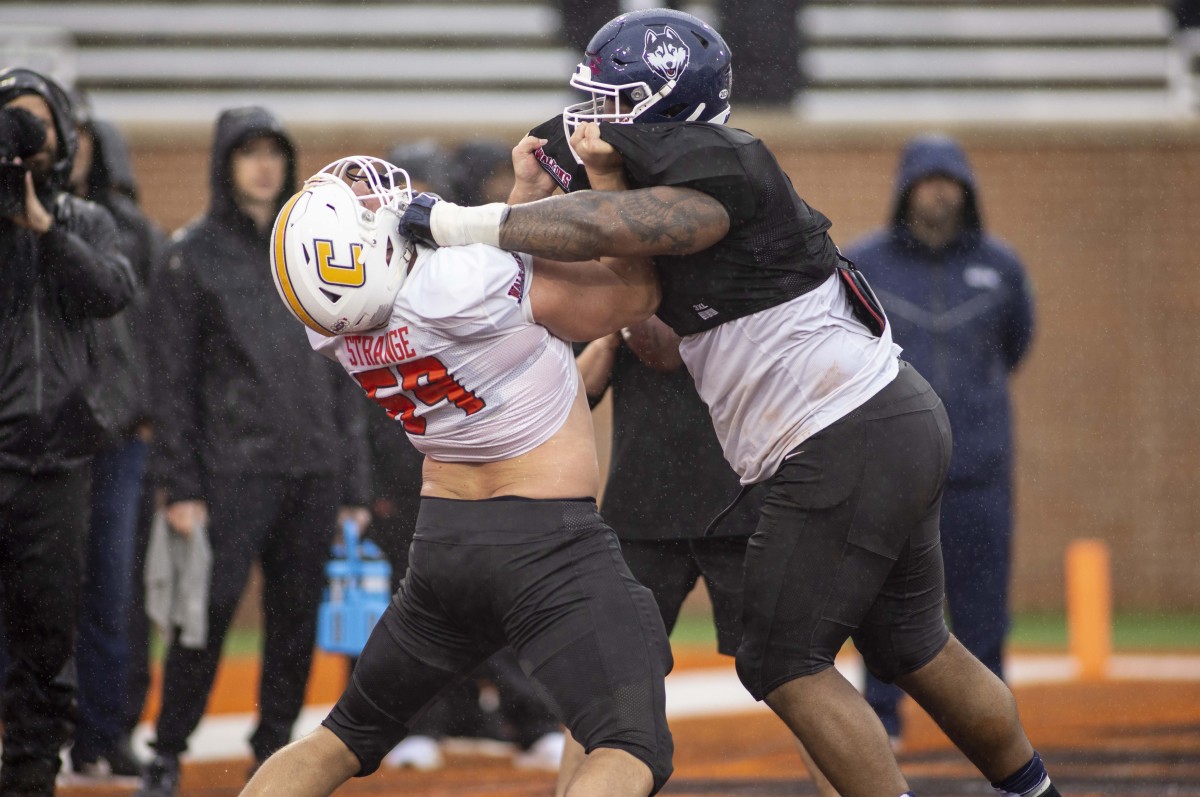 Feb 2, 2022; Mobile, AL, USA; National offensive lineman Cole Strange of Tennessee-Chattanooga (69) spars with National defensive lineman Travis Jones of Connecticut (57) during National practice for the 2022 Senior Bowl in Mobile, AL, USA.
