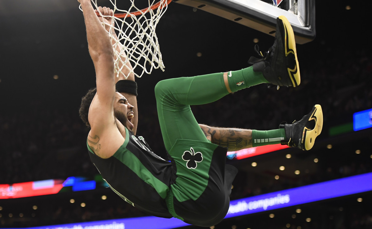 Feb 13, 2022; Boston, Massachusetts, USA; Boston Celtics forward Jayson Tatum (0) hangs onto the rim after dunking the ball during the second half against the Atlanta Hawks at TD Garden.