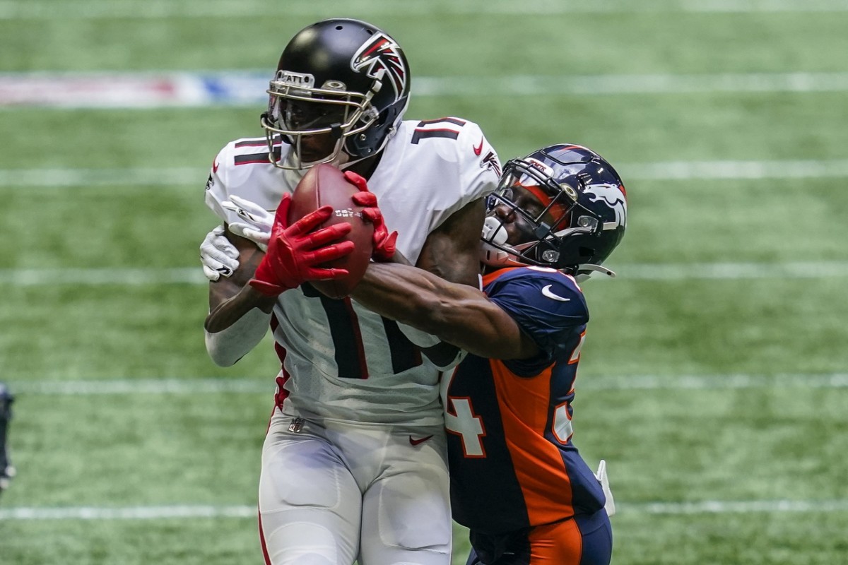 Atlanta Falcons wide receiver Julio Jones (11) makes a catch in front of Denver Broncos cornerback Essang Bassey (34) during the first quarter at Mercedes-Benz Stadium.