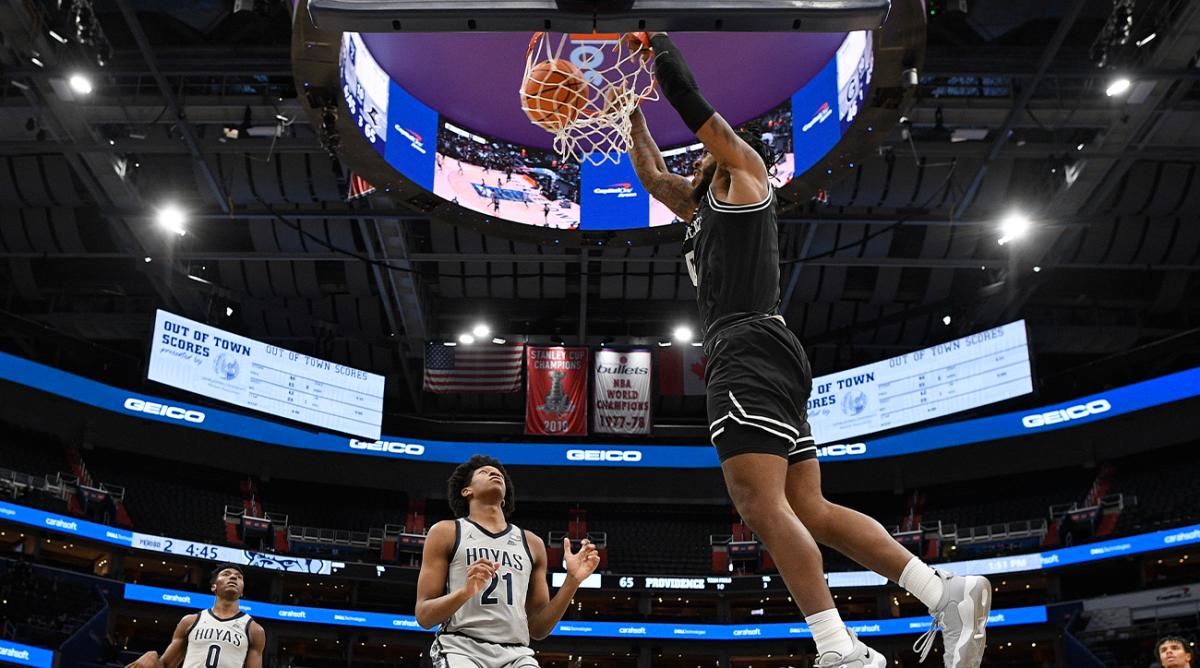 Providence center Nate Watson (0) dunks against Georgetown center Ryan Mutombo (21) and guard Aminu Mohammed (0) during the second half of an NCAA college basketball game, Sunday, Feb. 6, 2022, in Washington. Providence won 71-52.