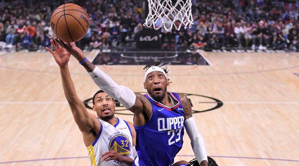 Los Angeles Clippers forward Robert Covington, right, shoots as Golden State Warriors forward Otto Porter Jr. defends during the first half of an NBA basketball game Monday, Feb. 14, 2022, in Los Angeles