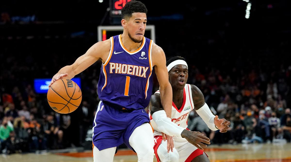 Phoenix Suns guard Devin Booker (1) drives against Houston Rockets guard Dennis Schroder during the second half of an NBA basketball game Wednesday, Feb. 16, 2022, in Phoenix. The Suns won 124-121.