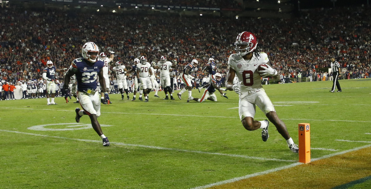 Nov 27, 2021; Auburn, Alabama, USA; Alabama Crimson Tide wide receiver John Metchie III (8) scores the game-winning touchdown against Auburn Tigers defensive back Roger McCreary (23) on a pass at Jordan-Hare Stadium. Alabama defeated Auburn in four overtimes. Mandatory Credit: Gary Cosby Jr.-USA TODAY Sports