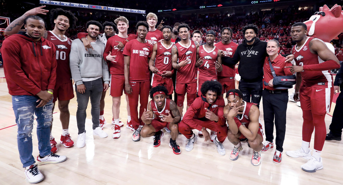 Former Arkansas Razorbacks who have turned pro take time to do photos with Hogs' coach Eric Musselman and the current team following a win over No. 16 Tennessee.