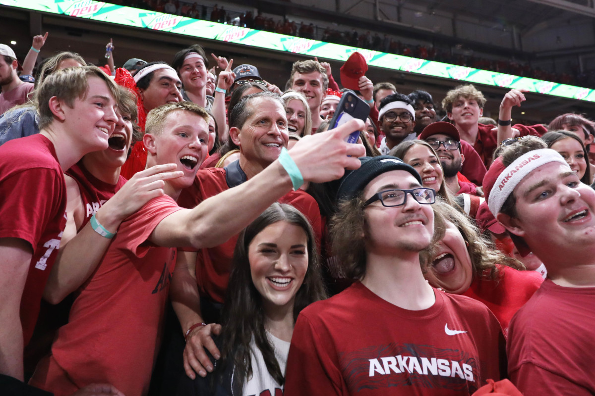Arkansas head coach Eric Musselman celebrates with students in the Razorback Trough after a red-out victory over No. 16 Tennessee.