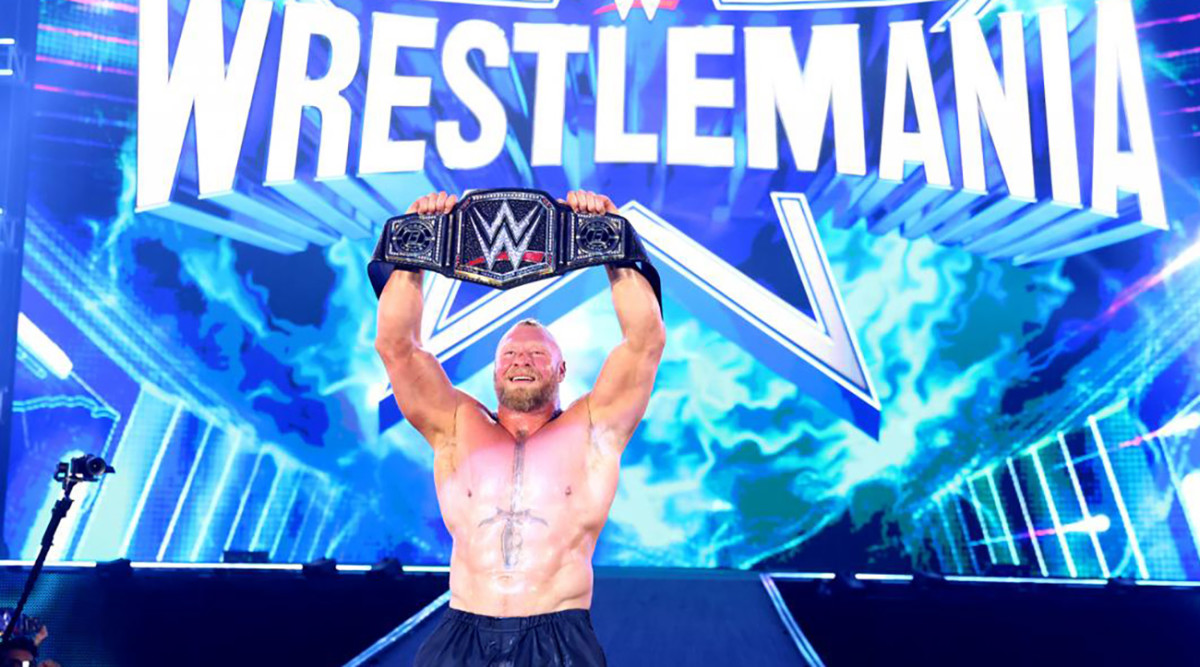 Brock Lesnar holds up the WWE champion belt after wrestling in the Elimination Chamber.