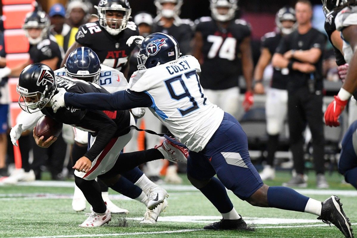 Tennessee Titans linebacker Monty Rice (56) and Tennessee Titans defensive tackle Trevon Coley (97) stop Atlanta Falcons quarterback AJ McCarron (5) during the second quarter of a preseason game at Mercedes-Benz Stadium Friday, Aug. 13, 2021 in Atlanta, Ga.