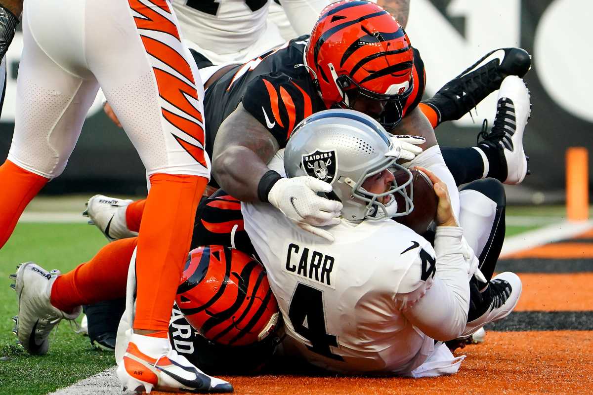 Las Vegas Raiders quarterback Derek Carr (4) is sacked by Cincinnati Bengals defensive end Sam Hubbard (94) and Cincinnati Bengals defensive end B.J. Hill (92) in the second quarter during an NFL AFC wild-card playoff game, Saturday, Jan. 15, 2022, at Paul Brown Stadium in Cincinnati. Las Vegas Raiders At Cincinnati Bengals Jan 15 Afc Wild Card Game