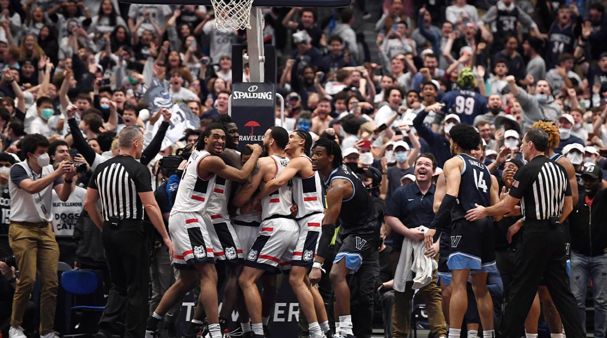 Connecticut players celebrate after regaining possession of the ball in the final second of the team's NCAA college basketball game against Villanova, Tuesday, Feb. 22, 2022, in Hartford, Conn.