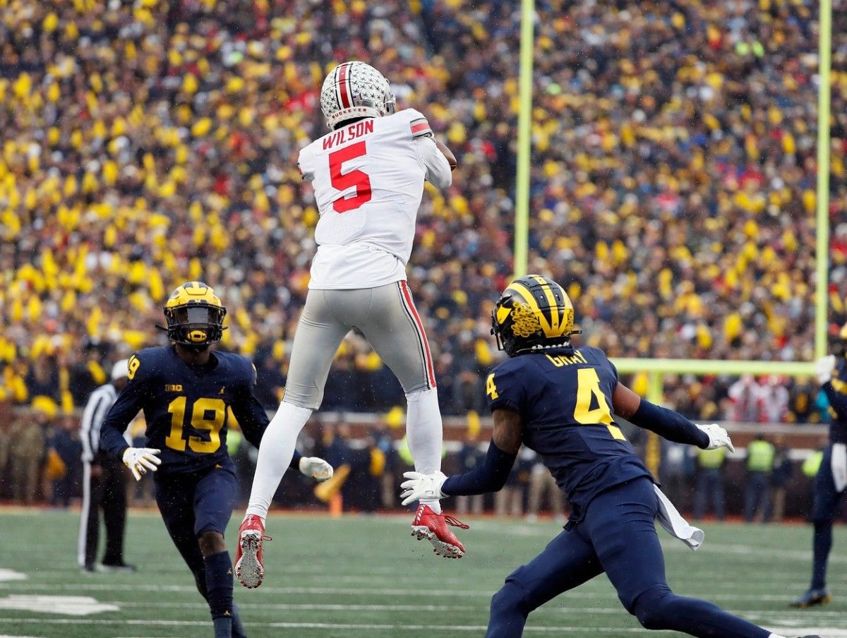 Ohio State Buckeyes wide receiver Garrett Wilson (5) jumps into the air to make a catch against Michigan Wolverines defensive back Vincent Gray (4) during the fourth quarter in a NCAA College football game at Michigan Stadium at Ann Arbor, Mi on November 27, 2021. Osu21um Kwr 56