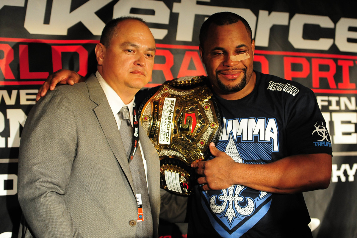 Former Strikeforce CEO and Bellator president Scott Coker (l.) poses with Daniel Cormier in 2012. 