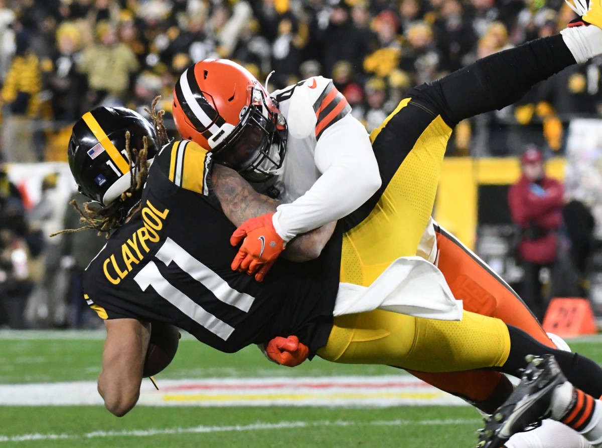 Jan 3, 2022; Pittsburgh, Pennsylvania, USA; Cleveland Browns linebacker Anthony Walker Jr. (4) tackles Pittsburgh Steelers wide receiver Chase Claypool (11) during the first quarter at Heinz Field. Mandatory Credit: Philip G. Pavely-USA TODAY Sports