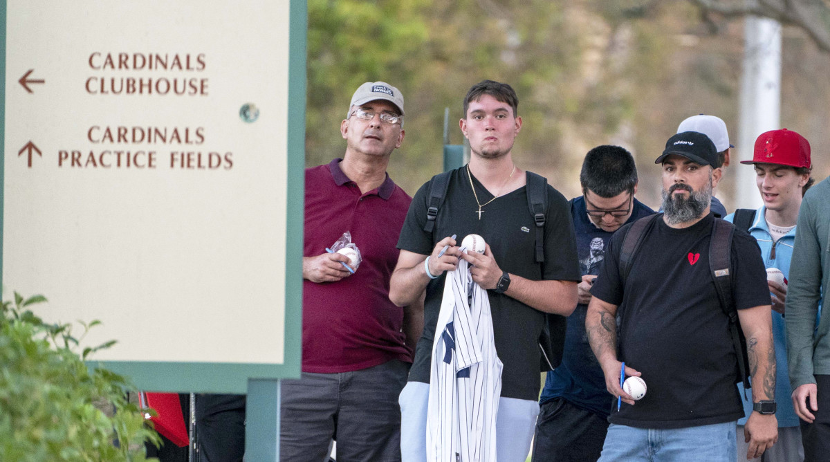 Feb 23, 2022; Jupiter, FL, USA; Baseball fans stand outside a gate in hopes of getting autographs from MLB players who attend contract negotiations at Roger Dean Stadium in Jupiter, Florida on February 23, 2022.