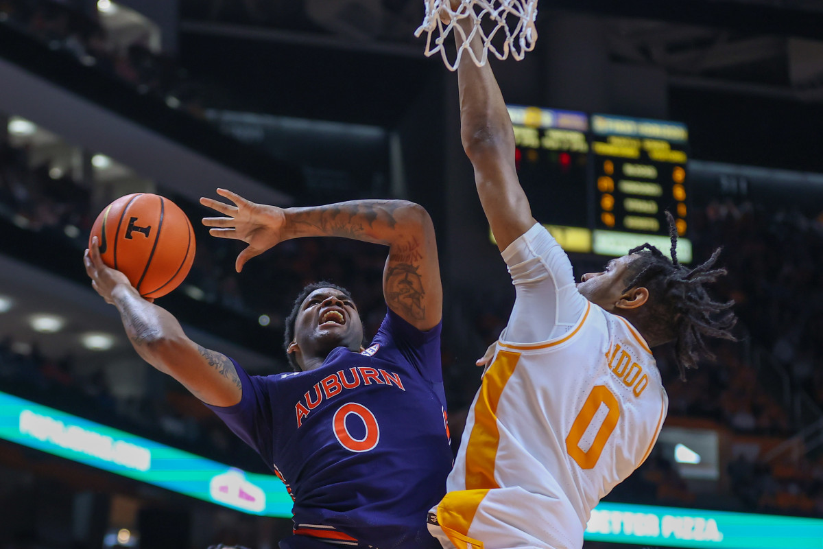 Feb 26, 2022; Knoxville, Tennessee, USA; Auburn Tigers guard K.D. Johnson (0) goes to the basket against Tennessee Volunteers forward Jonas Aidoo (0) during the first half at Thompson-Boling Arena. Mandatory Credit: Randy Sartin-USA TODAY Sports