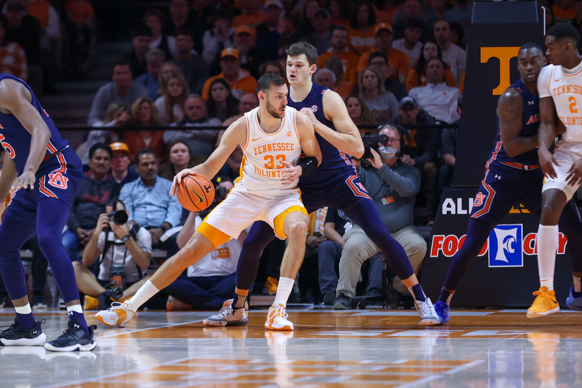 Feb 26, 2022; Knoxville, Tennessee, USA; Tennessee Volunteers forward Uros Plavsic (33) moves the ball against Auburn Tigers forward Walker Kessler (13) during the first half at Thompson-Boling Arena. Mandatory Credit: Randy Sartin-USA TODAY Sports