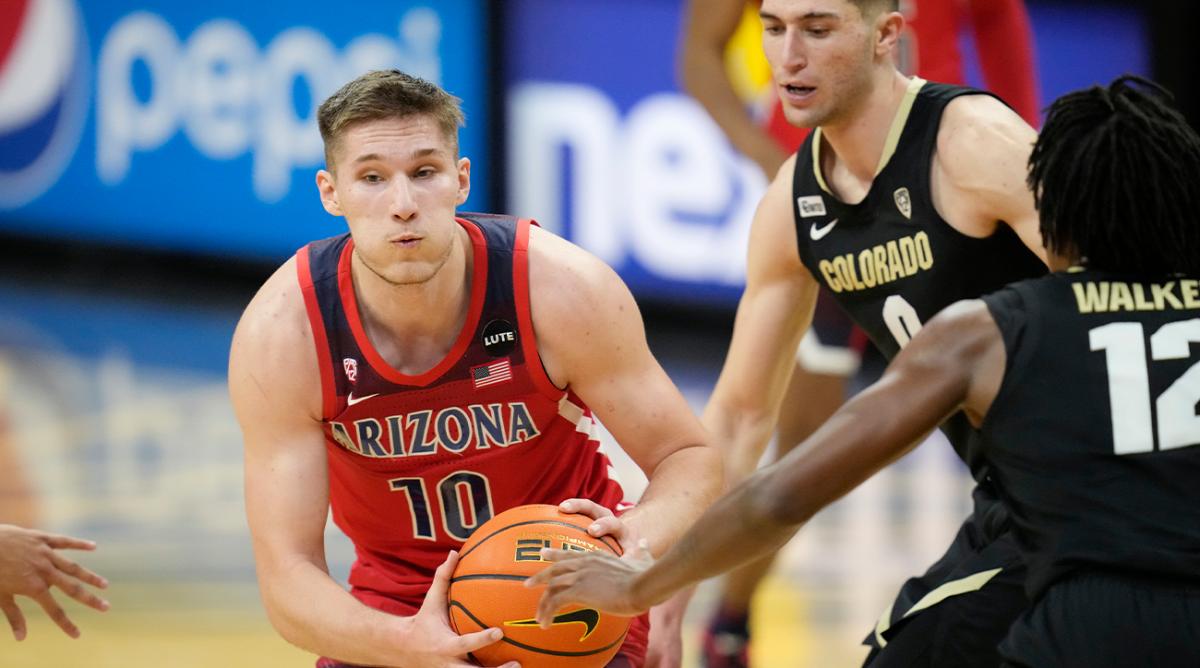 Arizona forward Azuolas Tubelis, left, drives the lane as Colorado guard Luke O'Brien, center, and forward Jabari Walker, right, defend in the first half of an NCAA college basketball game Saturday, Feb. 26, 2022, in Boulder, Colo.