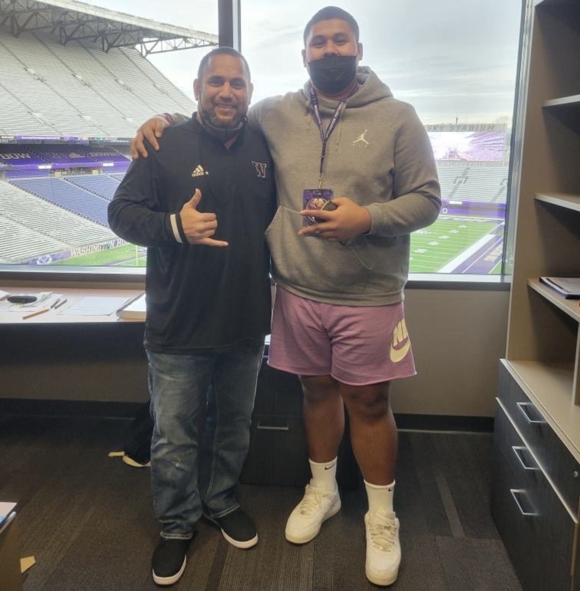 UW D-line coach Inoke Breckterfield and Amos Talalele stand for a recruiting photo.