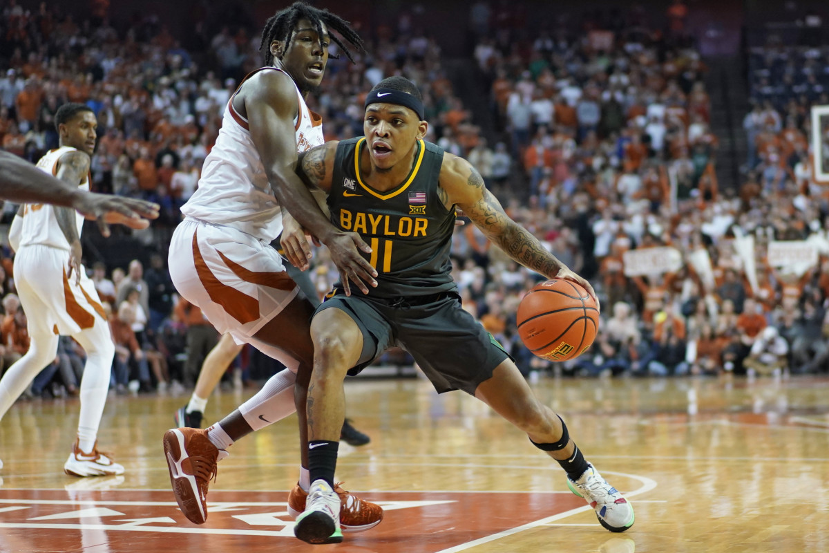 Feb 28, 2022; Austin, Texas, USA; Baylor Bears guard James Akinjo (11) drives to the basket while defended by Texas Longhorns guard Marcus Carr (2) during the second half at Frank C. Erwin Jr. Center.