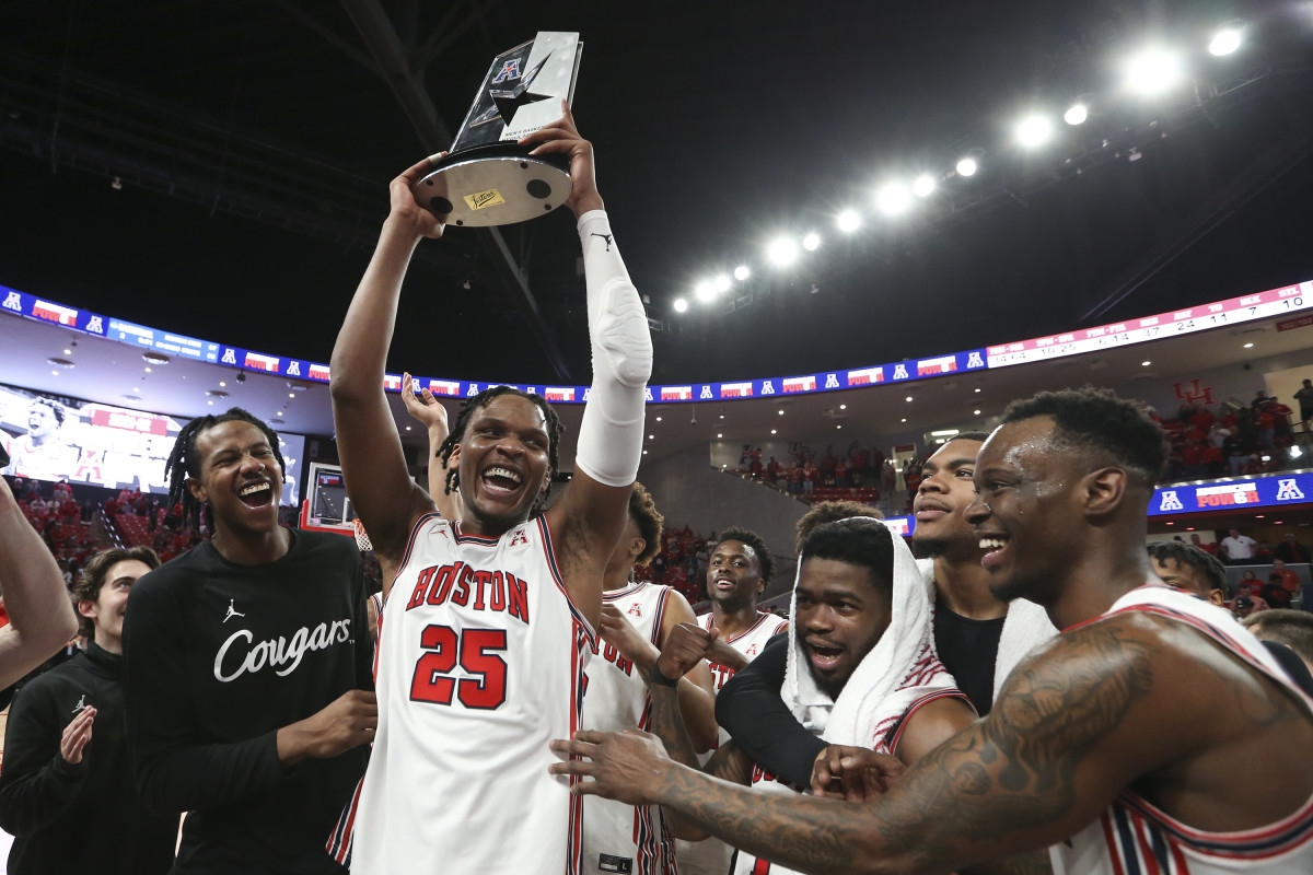 Houston Cougars center Josh Carlton (25) and guard Taze Moore (4) and teammates celebrate winning the American Athletic Conference after defeating the Temple Owls at Fertitta Center.
