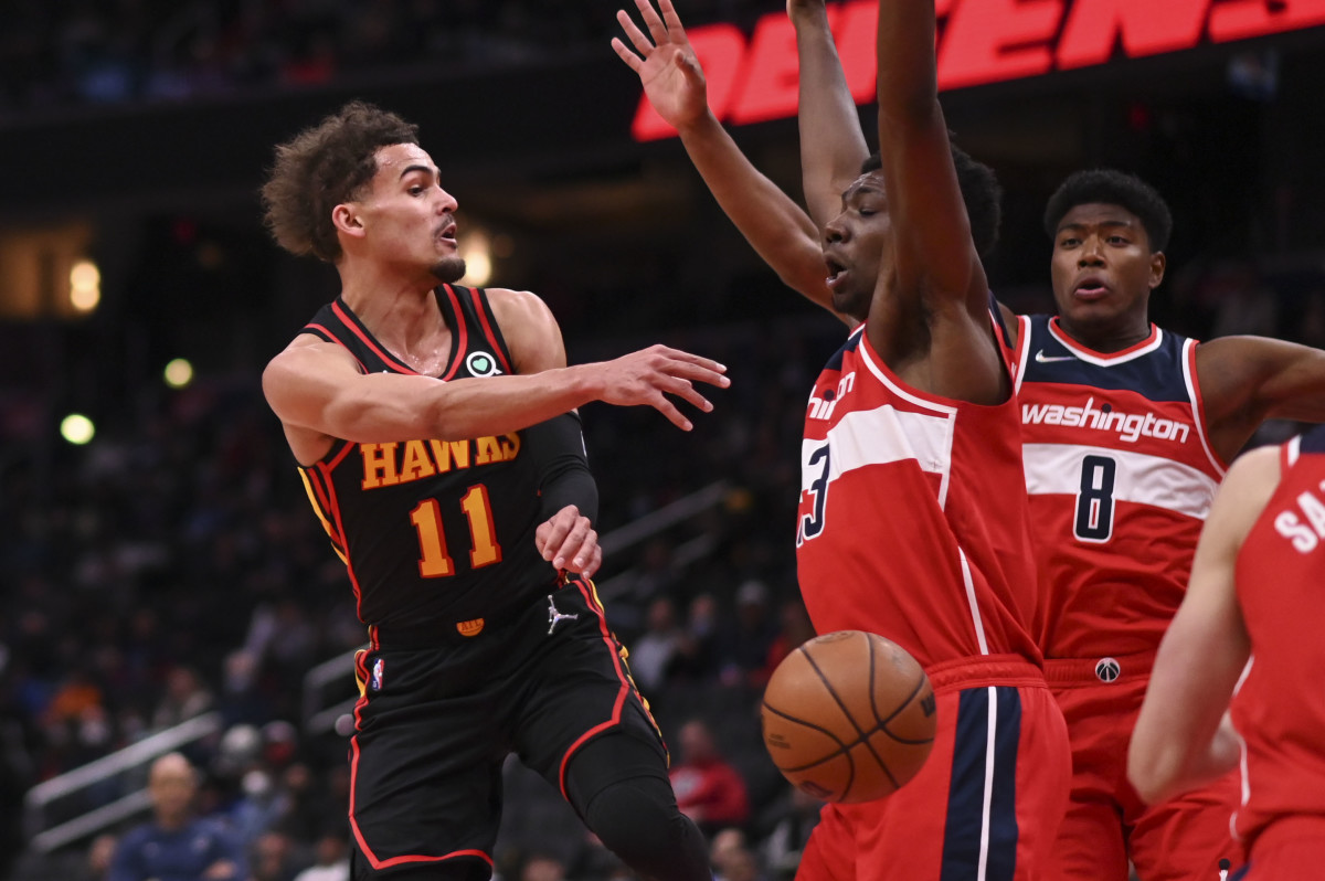 Mar 4, 2022; Washington, District of Columbia, USA; Atlanta Hawks guard Trae Young (11) pass bounces off Washington Wizards center Thomas Bryant (13) during the first half at Capital One Arena.