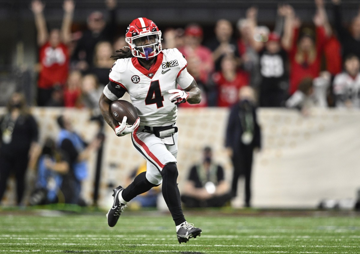 Jan 10, 2022; Indianapolis, IN, USA; Georgia Bulldogs running back James Cook (4) runs the ball against the Alabama Crimson Tide in the third quarter during the 2022 CFP college football national championship game at Lucas Oil Stadium.